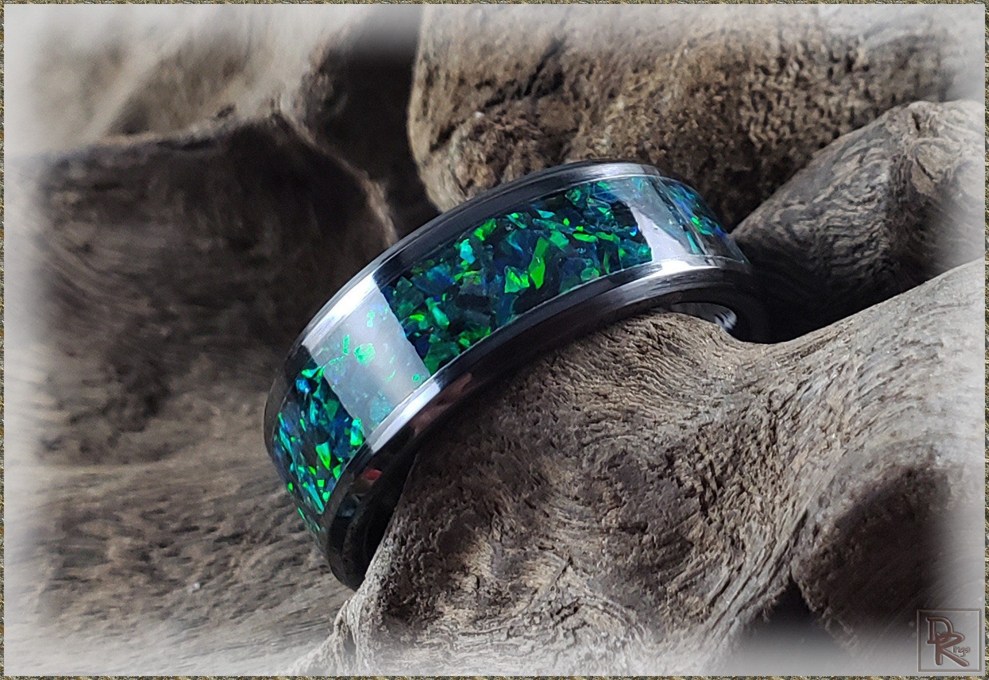 DR Rings ceramic ring with blue and green inlay resting on textured wood background