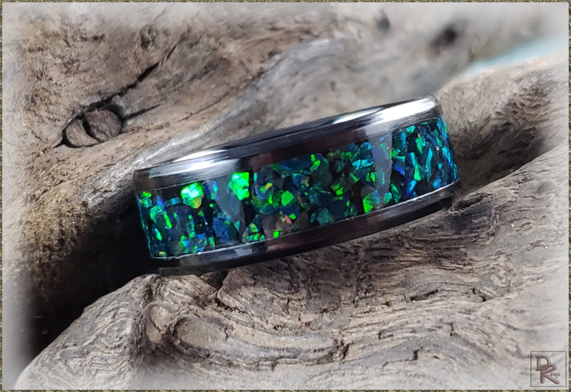 DR Rings ceramic ring with blue and green opal inlay on rustic wooden surface