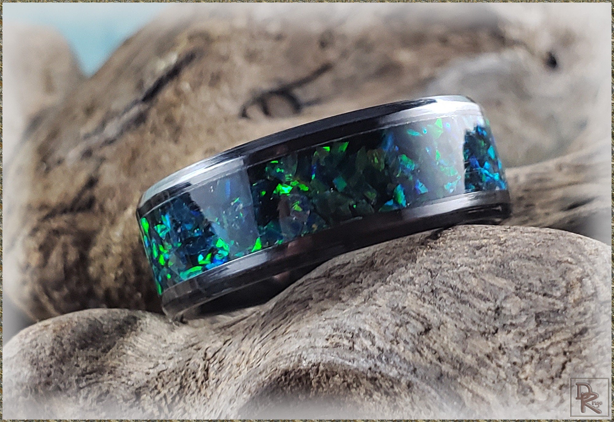 DR Rings ceramic ring with blue and green opal inlay on textured natural background