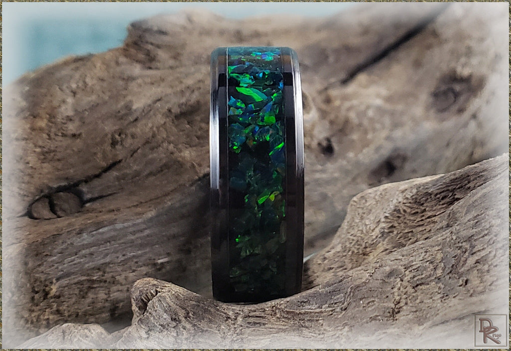 DR Rings ceramic ring with black band and green blue opal inlay on wooden background
