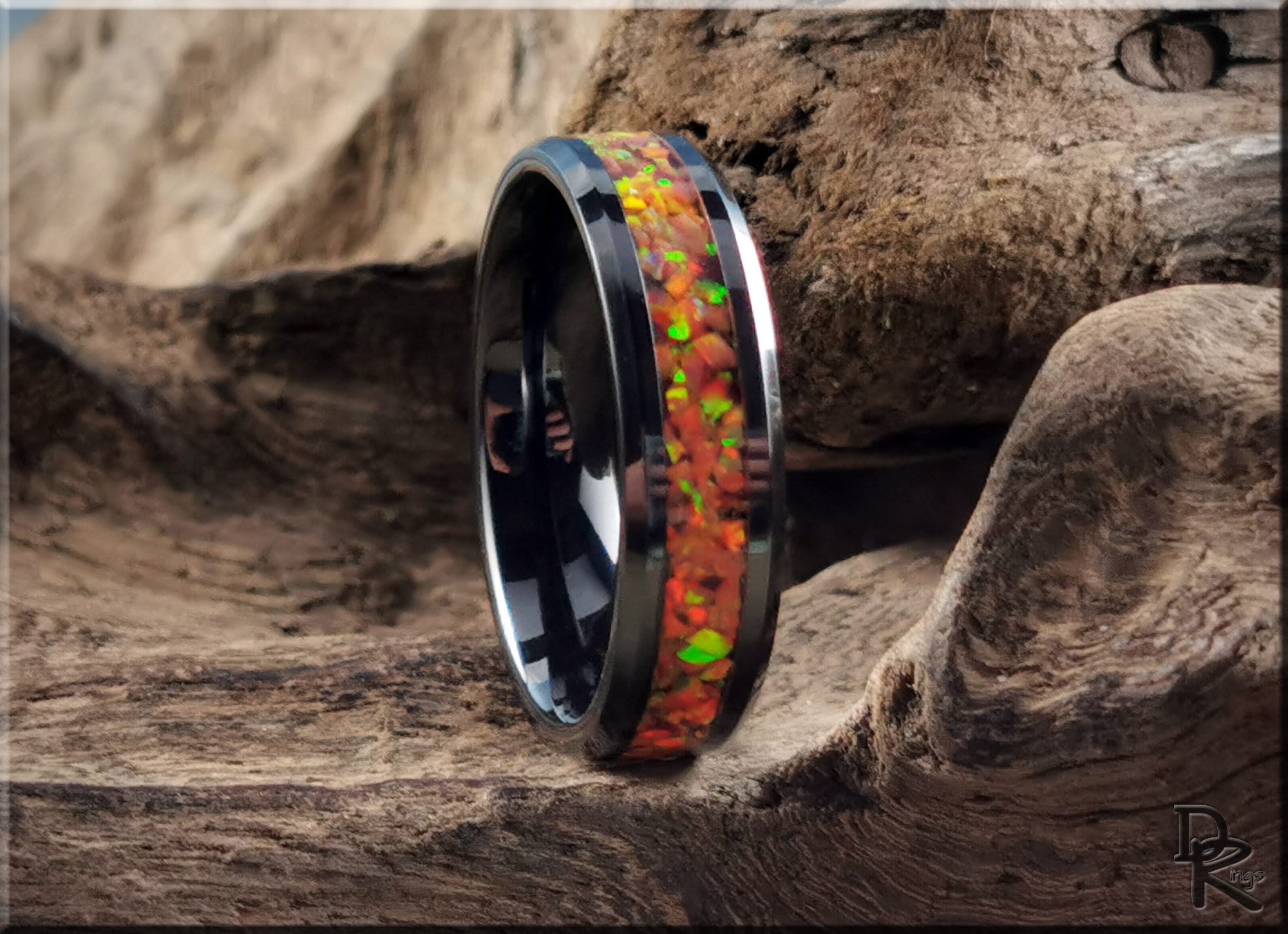 Black ceramic ring with inlay featuring vibrant orange and green opal design by DR Rings