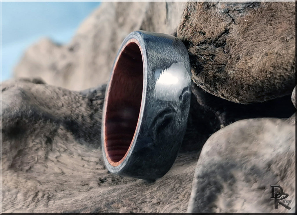 DR Rings grey maple ring with polished dark grey finish and wooden interior on natural rock background