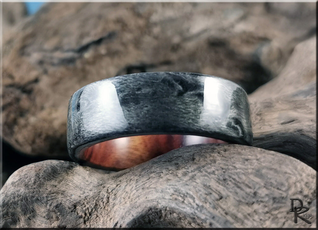 DR Rings grey maple ring with polished textured surface resting on natural wood background