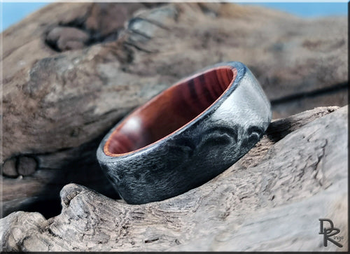DR Rings grey maple ring with textured grey exterior and smooth polished wood interior on rustic wood