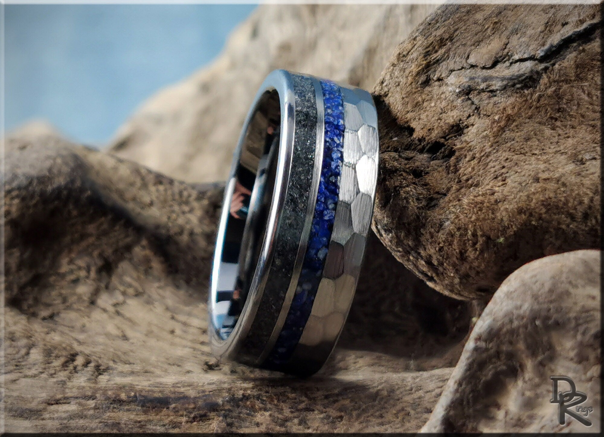 Hammered tungsten ring with two inlays featuring blue and black stone details on textured metal