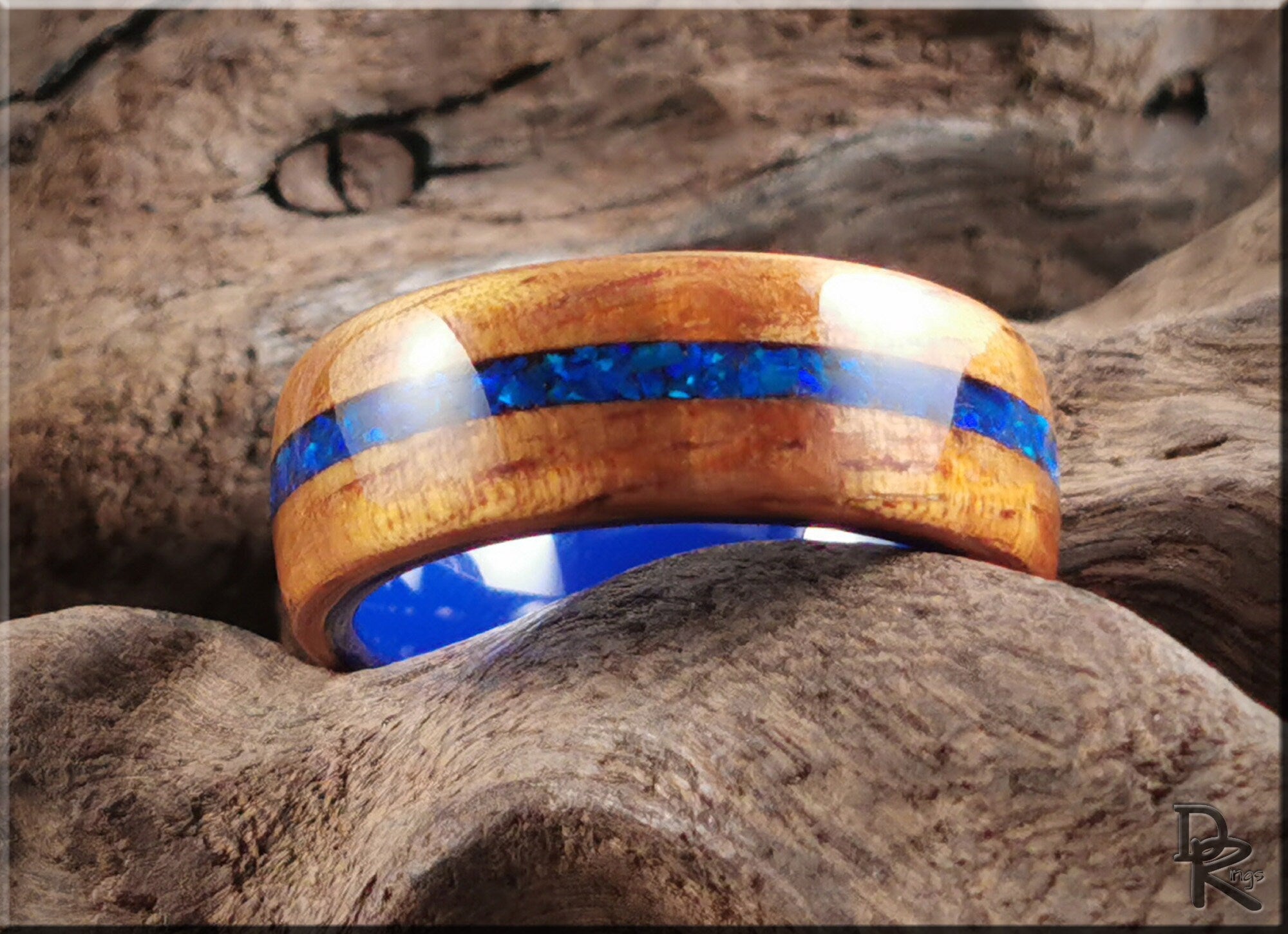 Koa wood ring with opal and ceramic blue inlay band by DR Rings on natural wood background