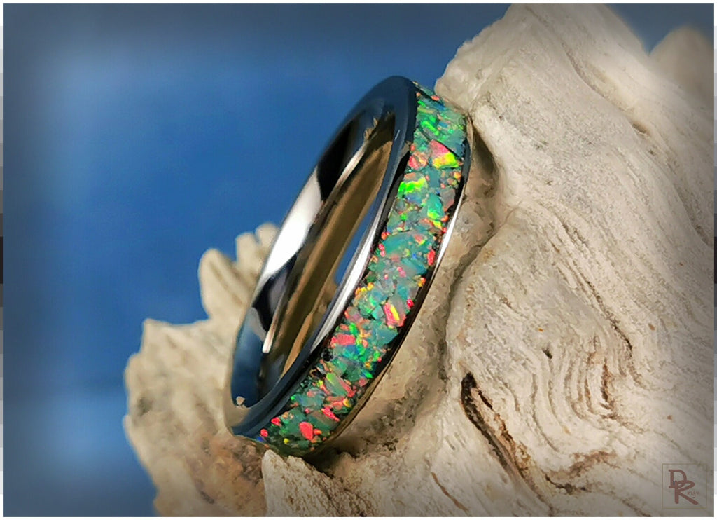 Narrow titanium ring with opal inlay showing vibrant green and red colors by DR Rings