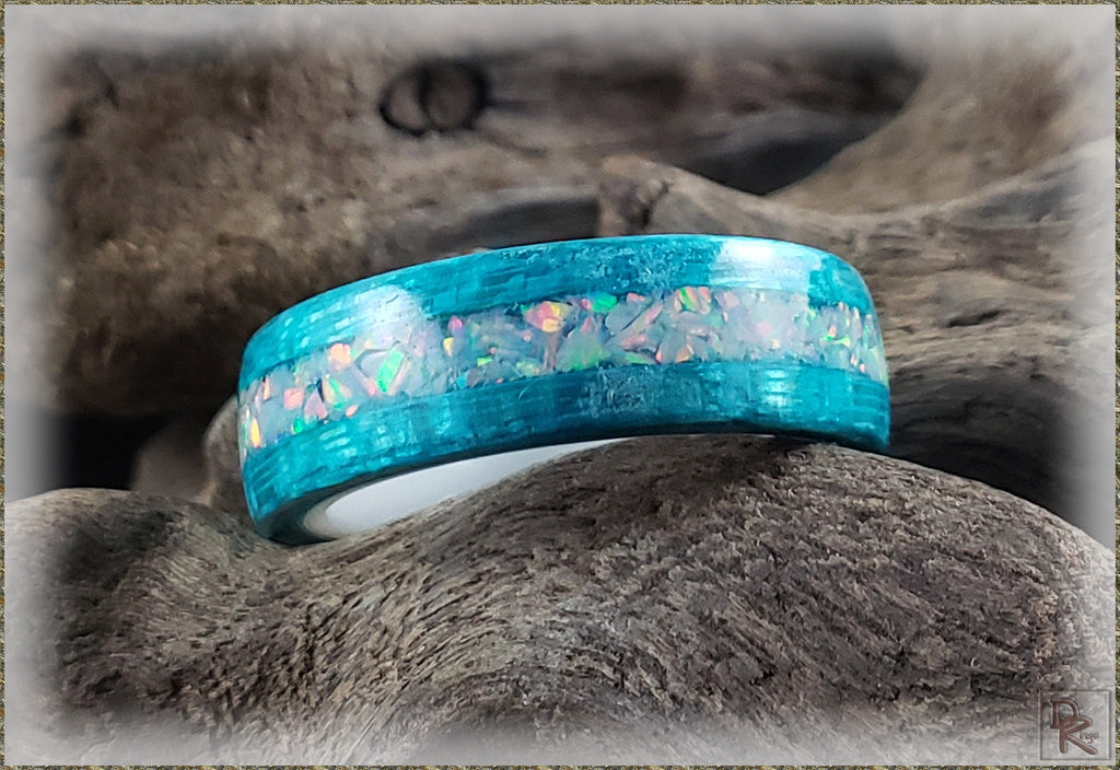 DR Rings opal inlay wood ring with vibrant blue and iridescent opal accents on natural wood background