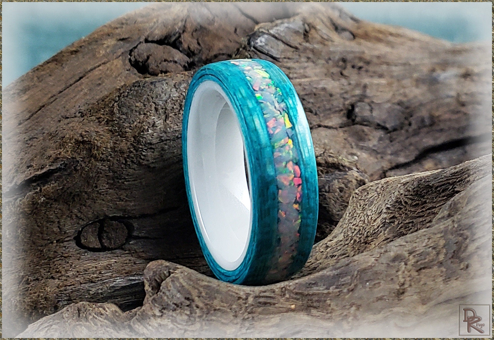 DR Rings opal inlay wood ring with vibrant blue and multicolor opal accents on natural wood background