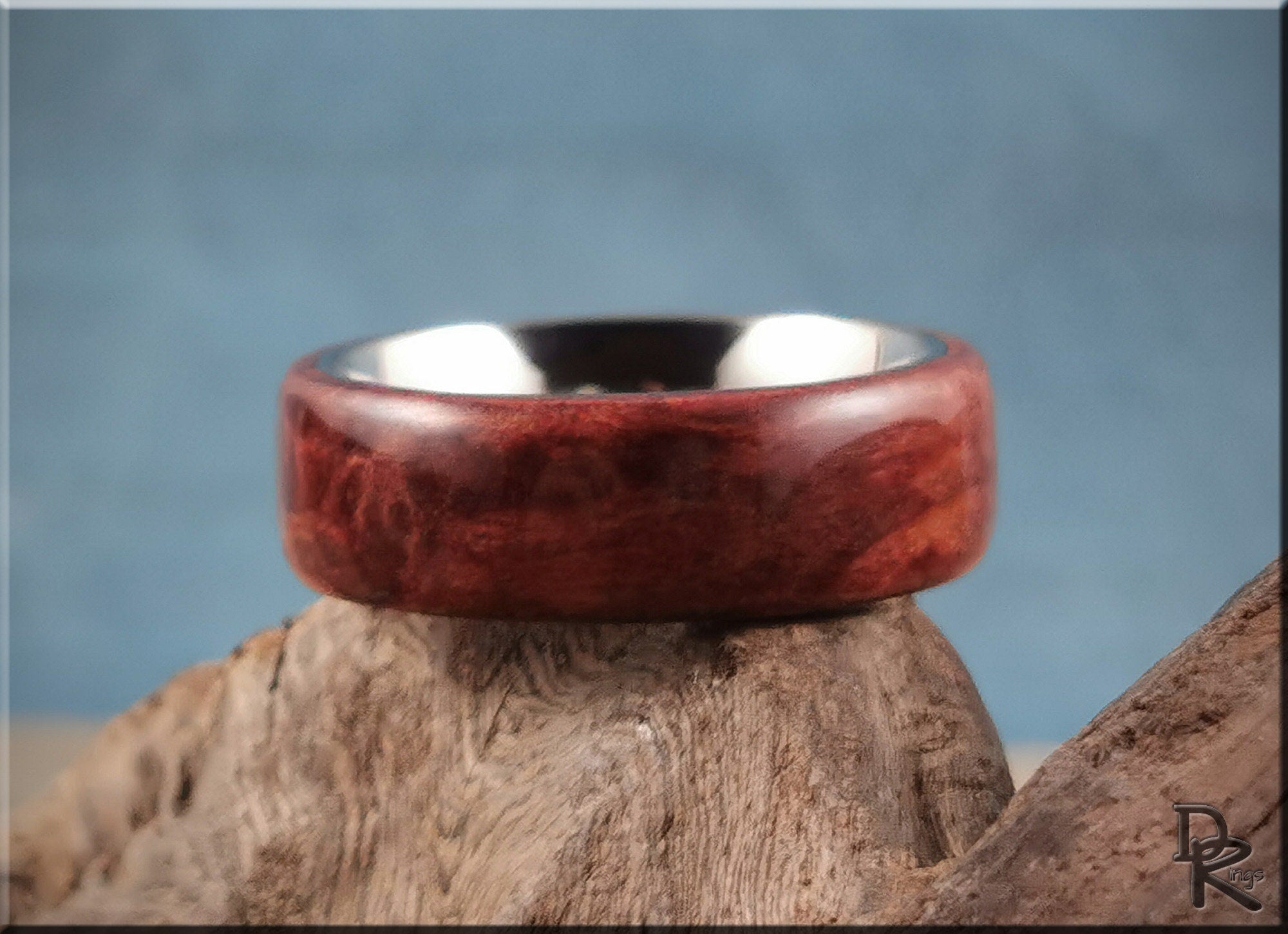 DR Rings redwood ring on titanium with smooth polished wood finish displayed on natural wood