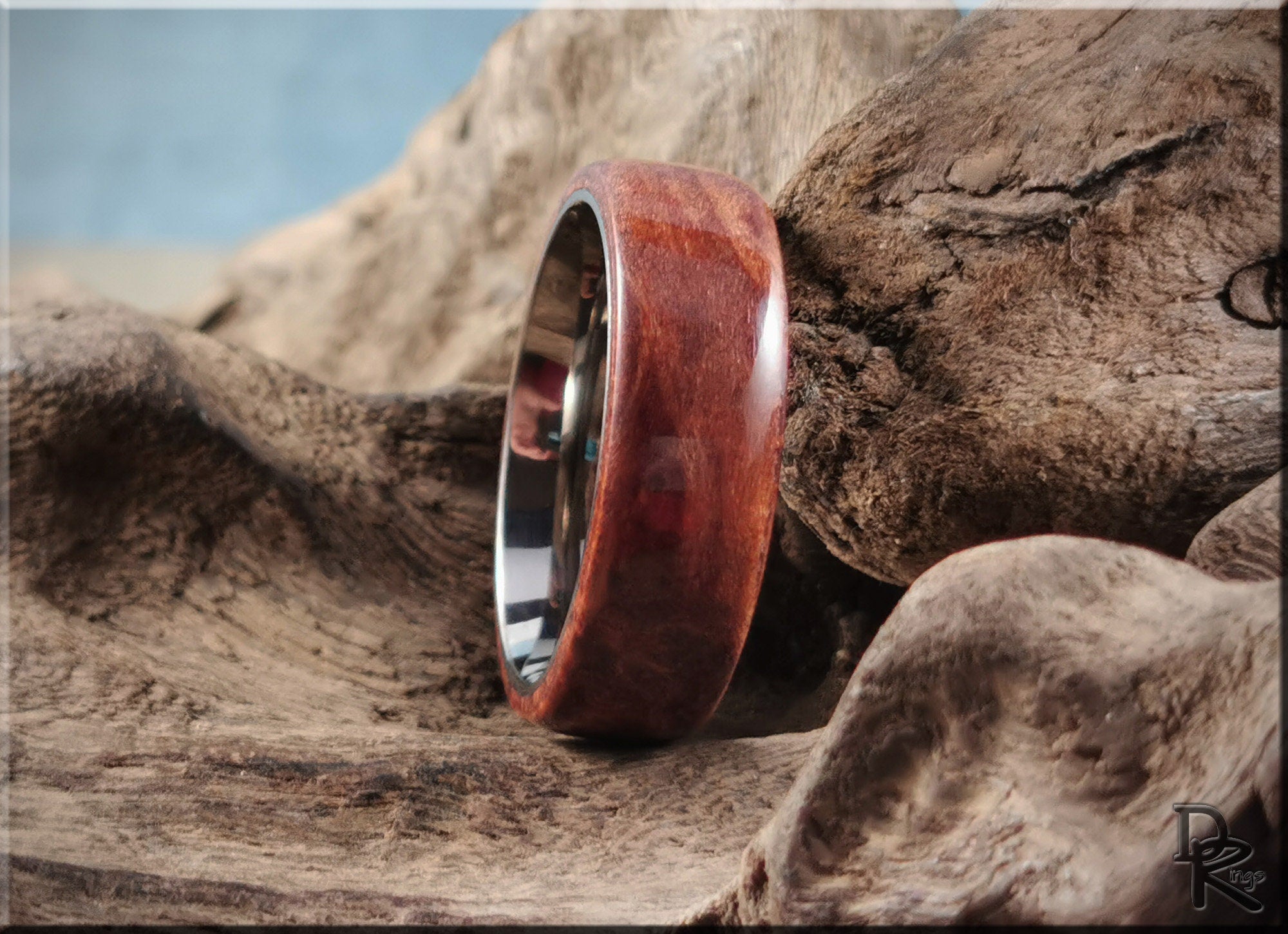 Redwood ring on titanium band displayed on rustic textured wood background by DR Rings