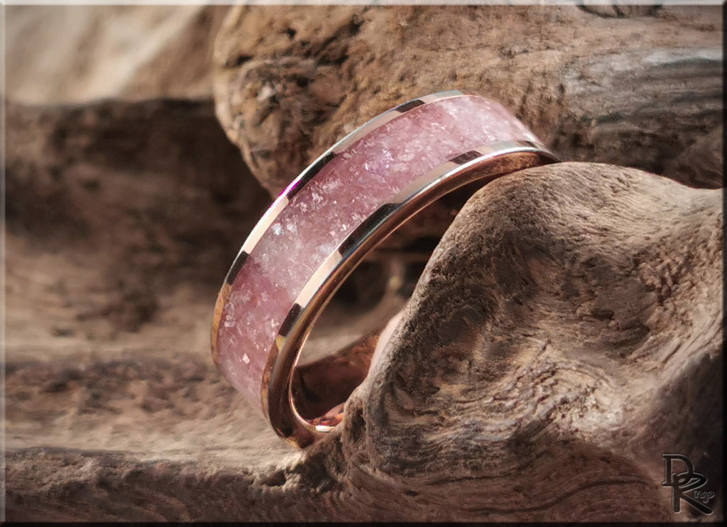 Rose tungsten ring with lepidolite featuring a pink stone inlay on a rustic wood background