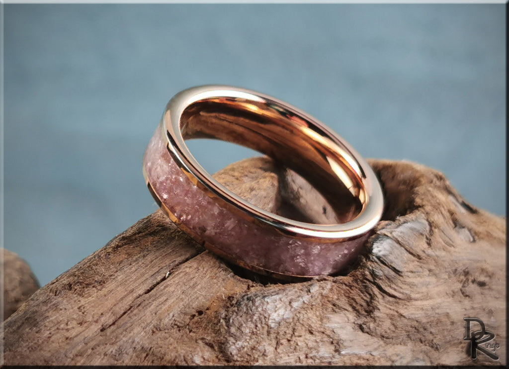 Rose tungsten ring with lepidolite inlay resting on textured wood background by DR Rings