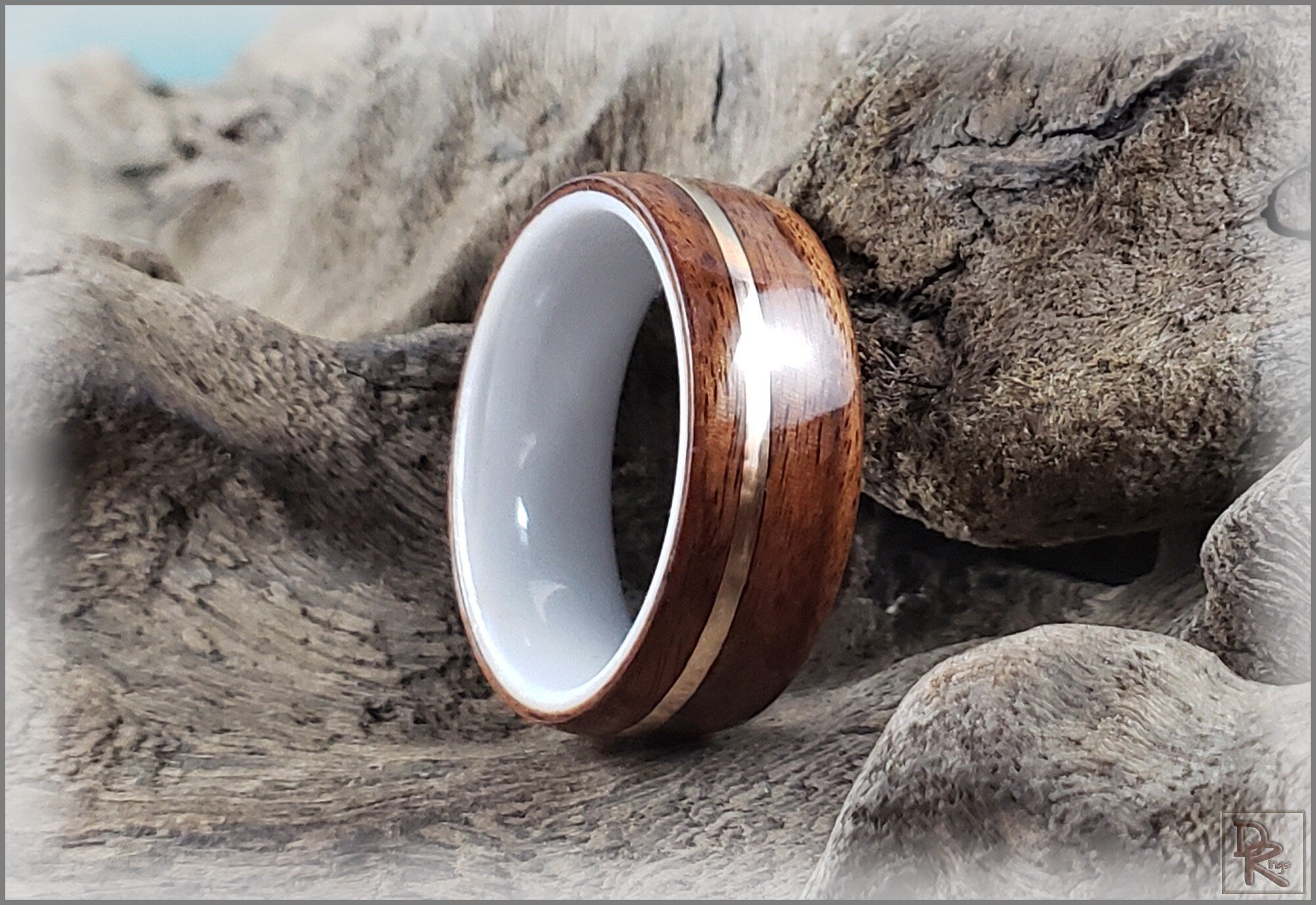 Rosewood ring with wire inlay handcrafted by DR Rings displayed on rustic wood background