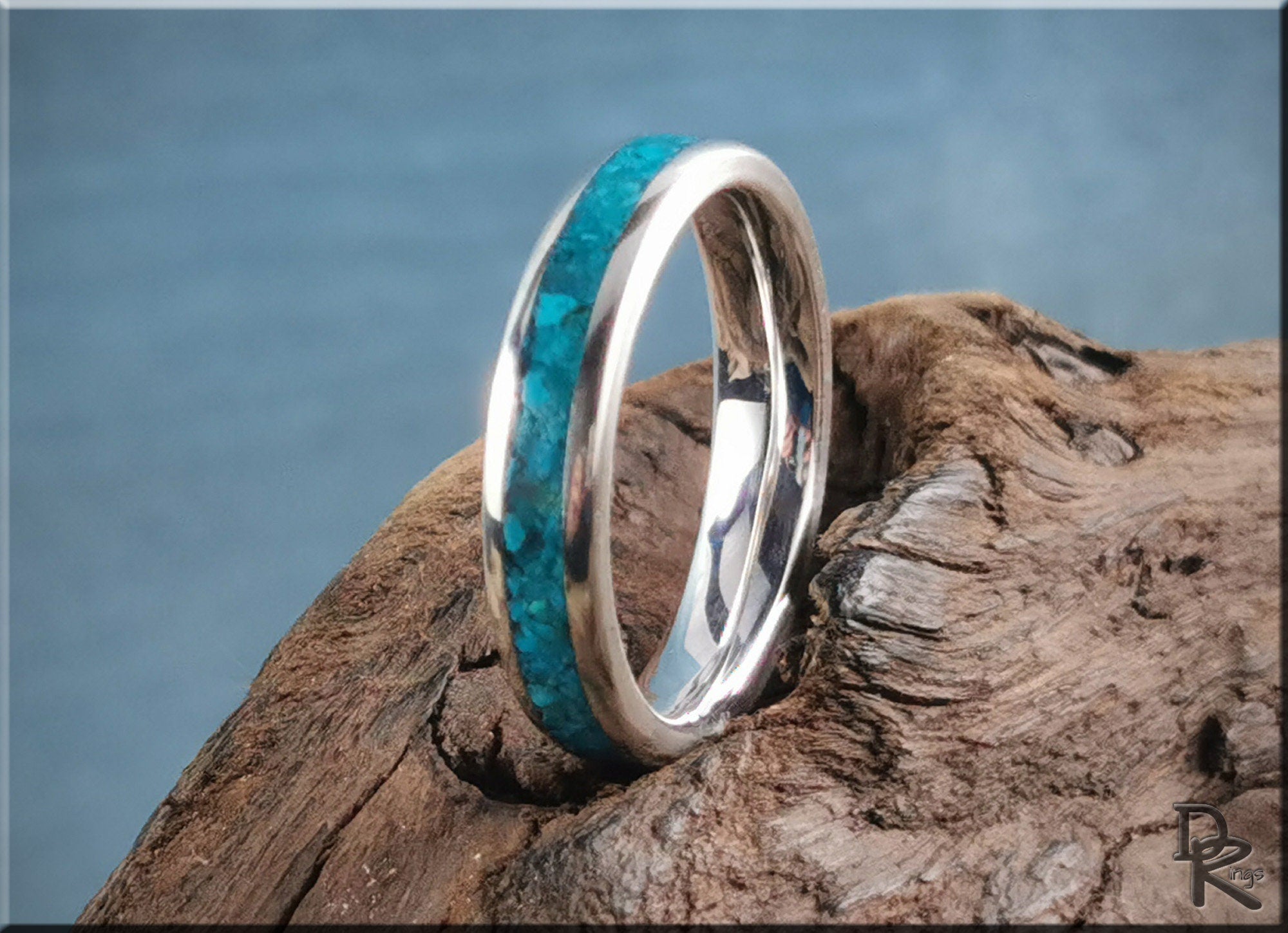 DR Rings silver ring with inlay featuring a vibrant blue turquoise design on rustic wooden background