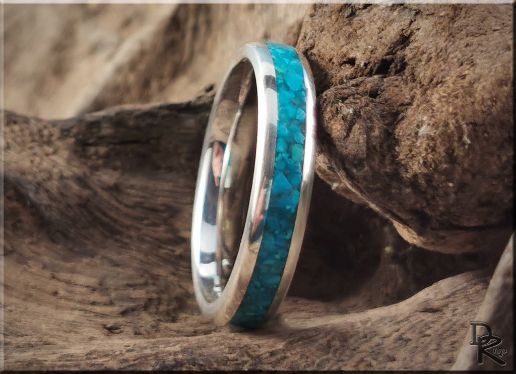 DR Rings silver ring with inlay featuring a vibrant turquoise stone set against natural wood background