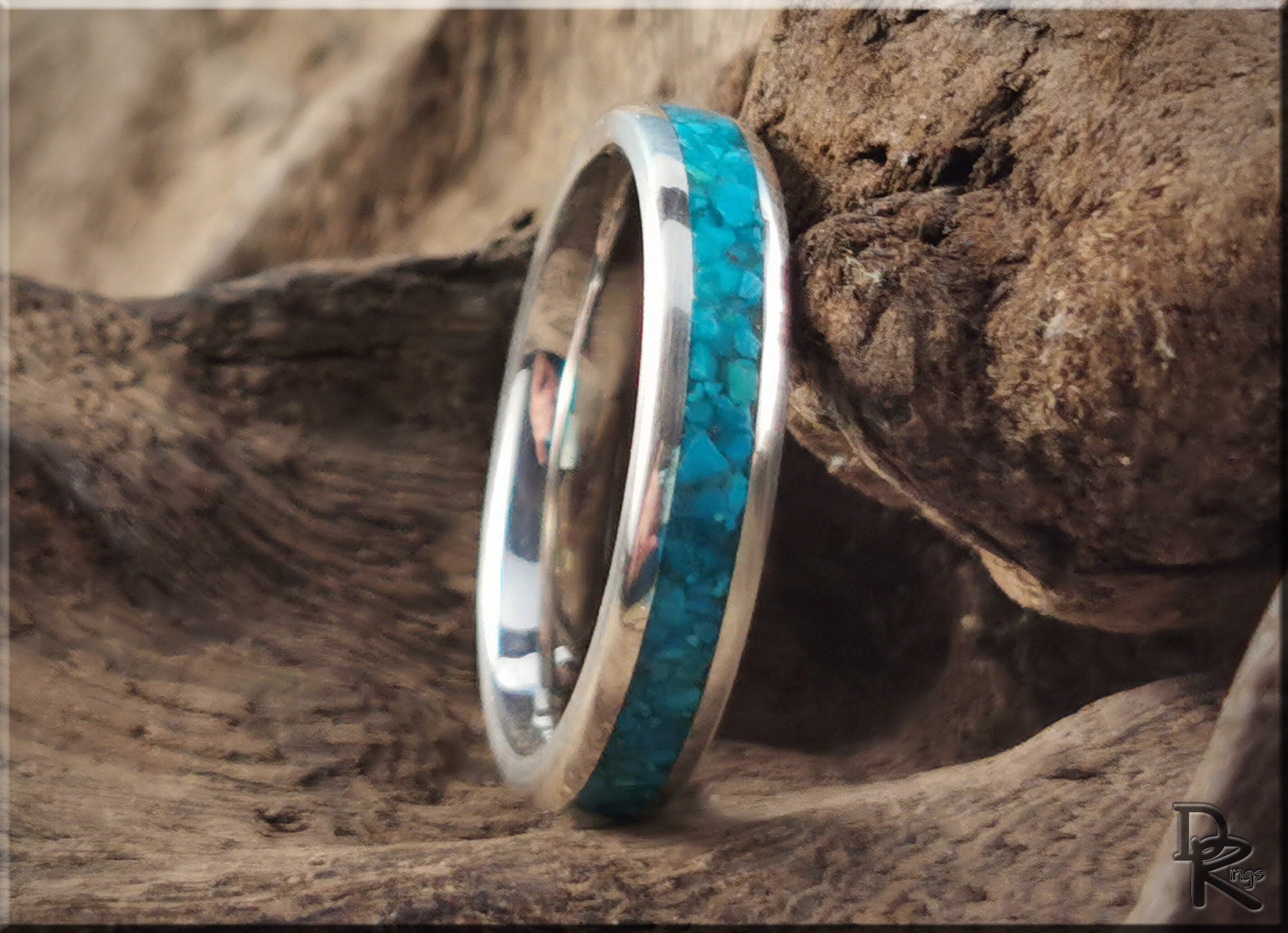 DR Rings silver ring with inlay featuring a vibrant turquoise stone set against natural wood background