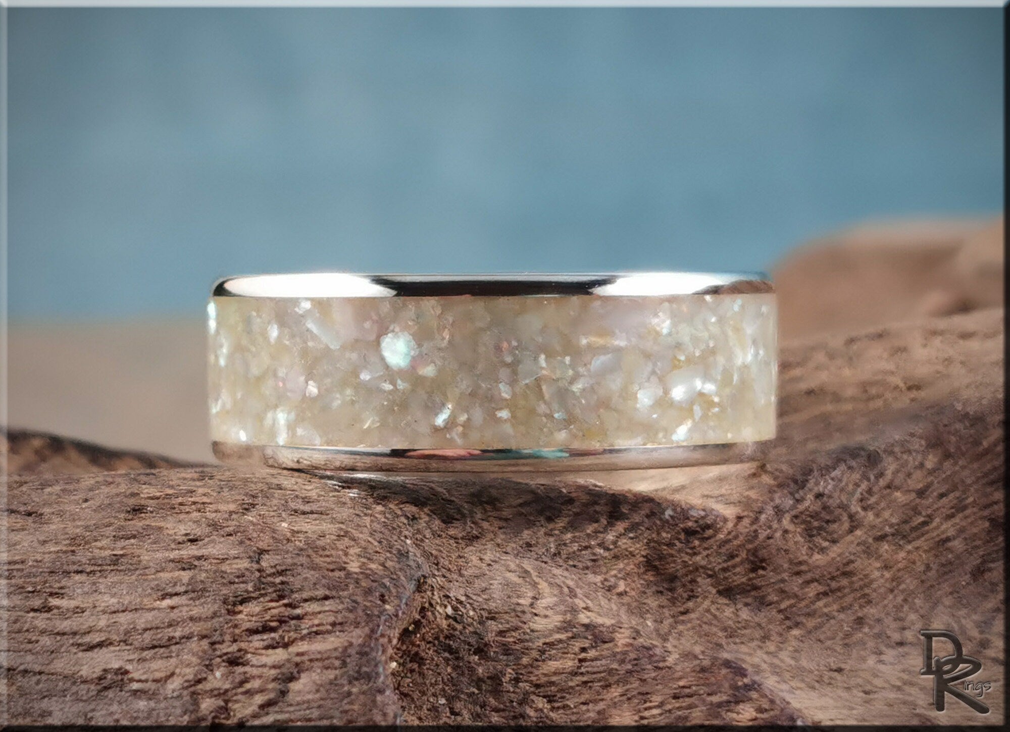 Sterling silver ring with pearl inlay featuring a polished silver band and iridescent pearl details