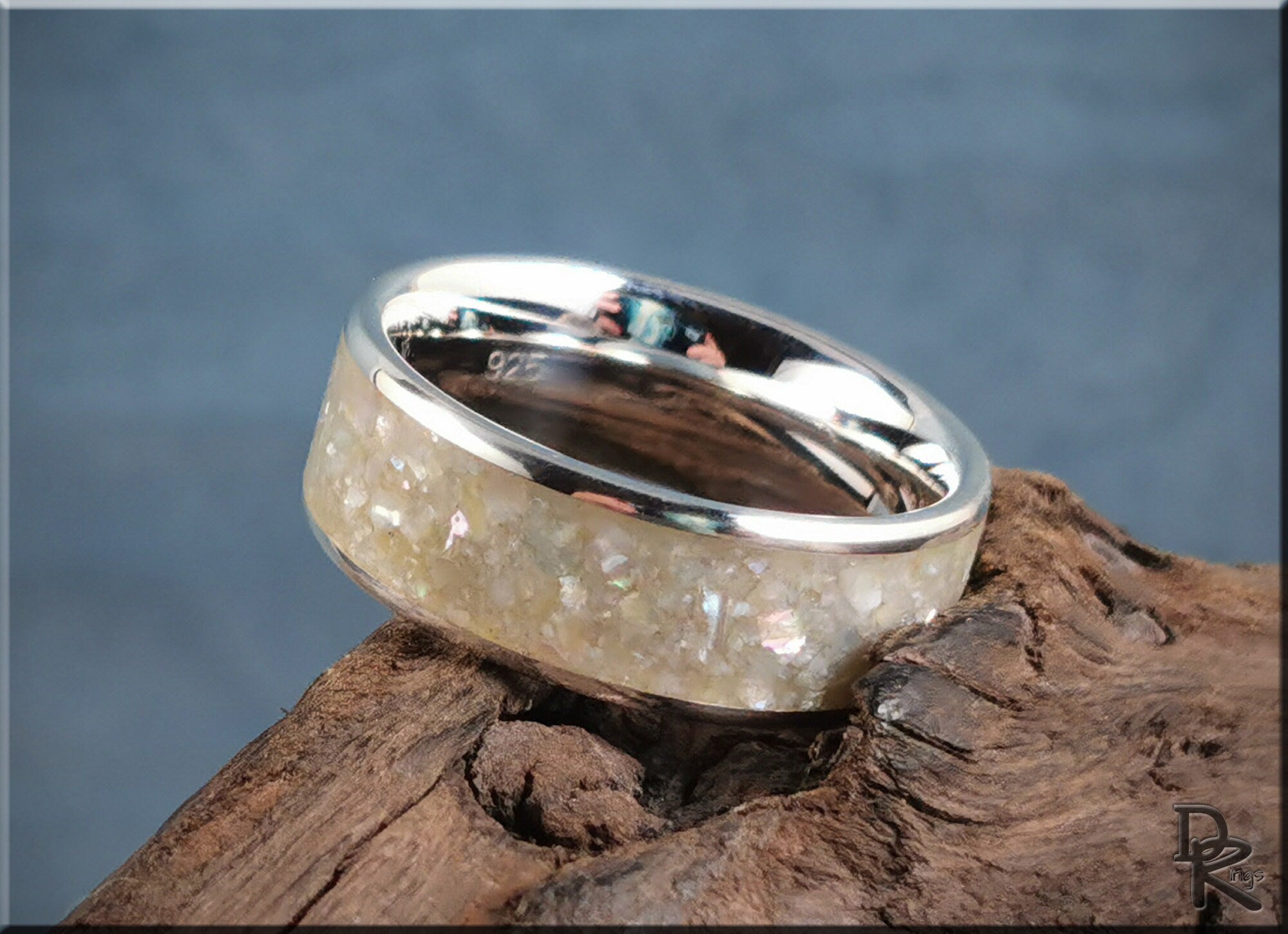 Sterling silver ring with pearl inlay featuring a polished band and textured pearl design