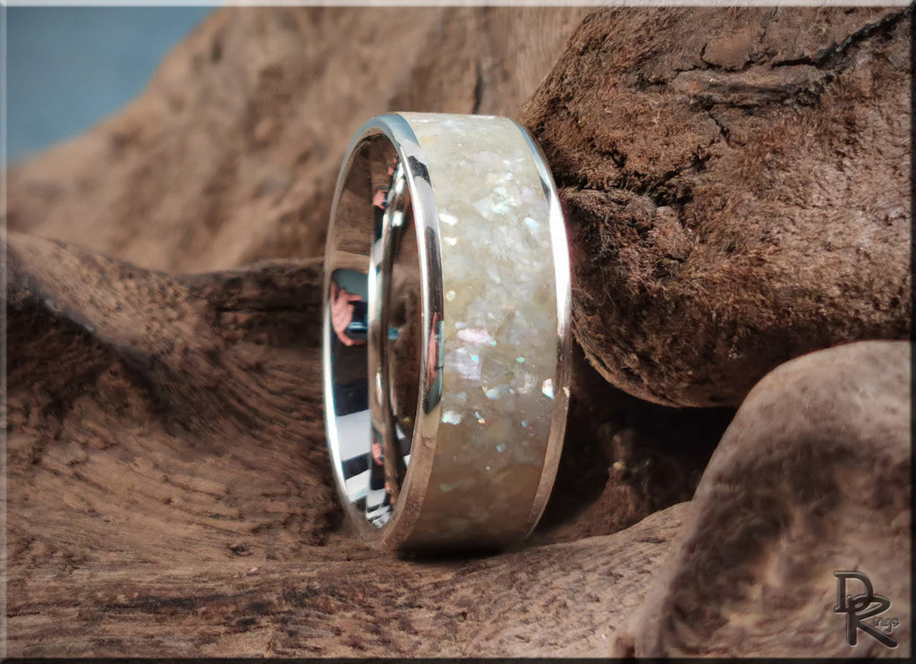 Sterling silver ring with pearl inlay shown on rustic wood background by DR Rings