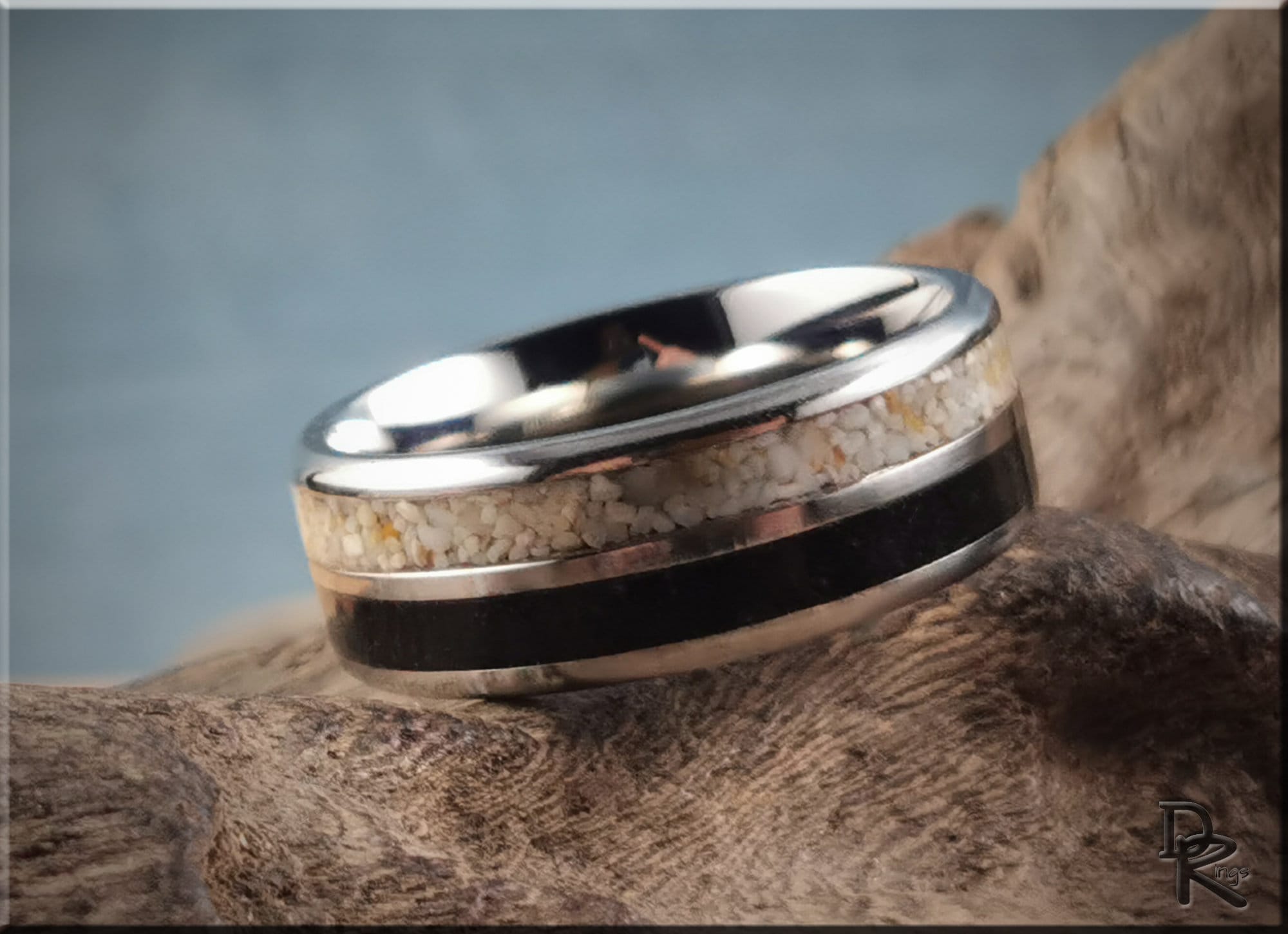 Titanium ring with dual sand inlays by DR Rings displayed on textured wood background