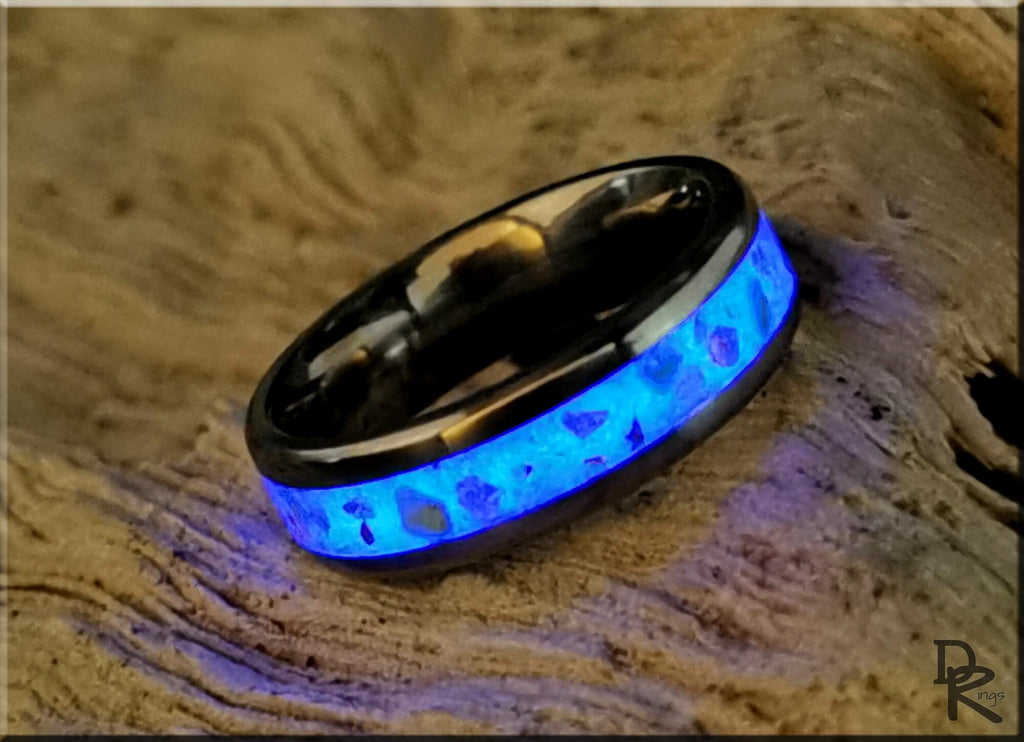 DR Rings titanium ring with inlay glowing blue on textured wooden surface
