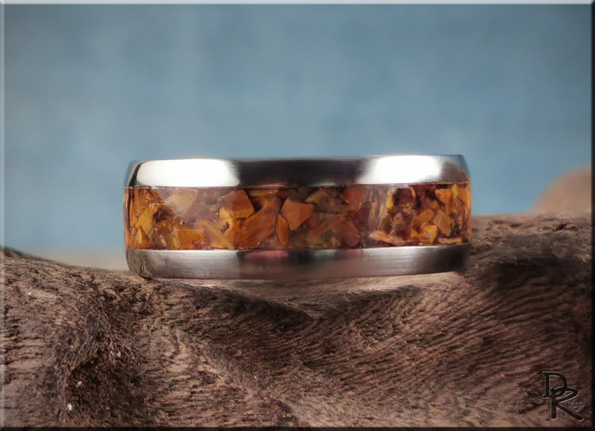 DR Rings titanium ring with inlay featuring a polished silver band and amber stone inlay on rustic wood