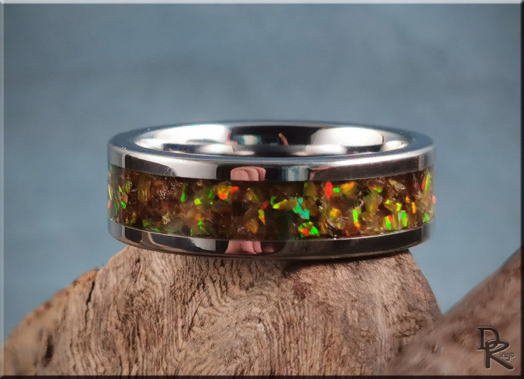 DR Rings titanium ring with inlay featuring colorful opal design on wooden background