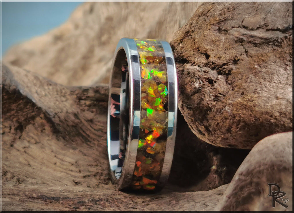 DR Rings titanium ring with inlay featuring colorful opal design on rustic wooden background