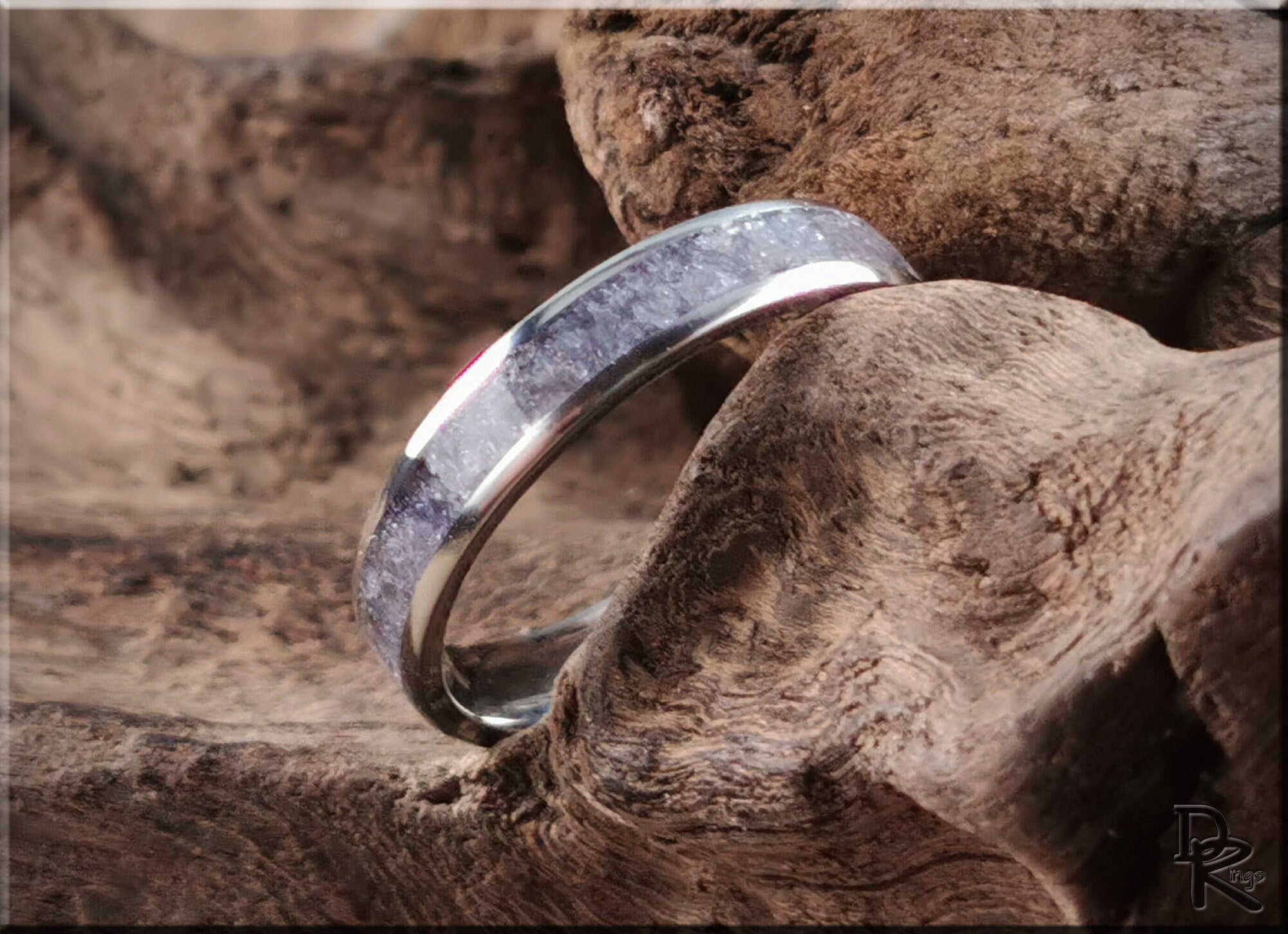 DR Rings titanium ring with inlay featuring a polished silver band with textured inlay on natural wood background