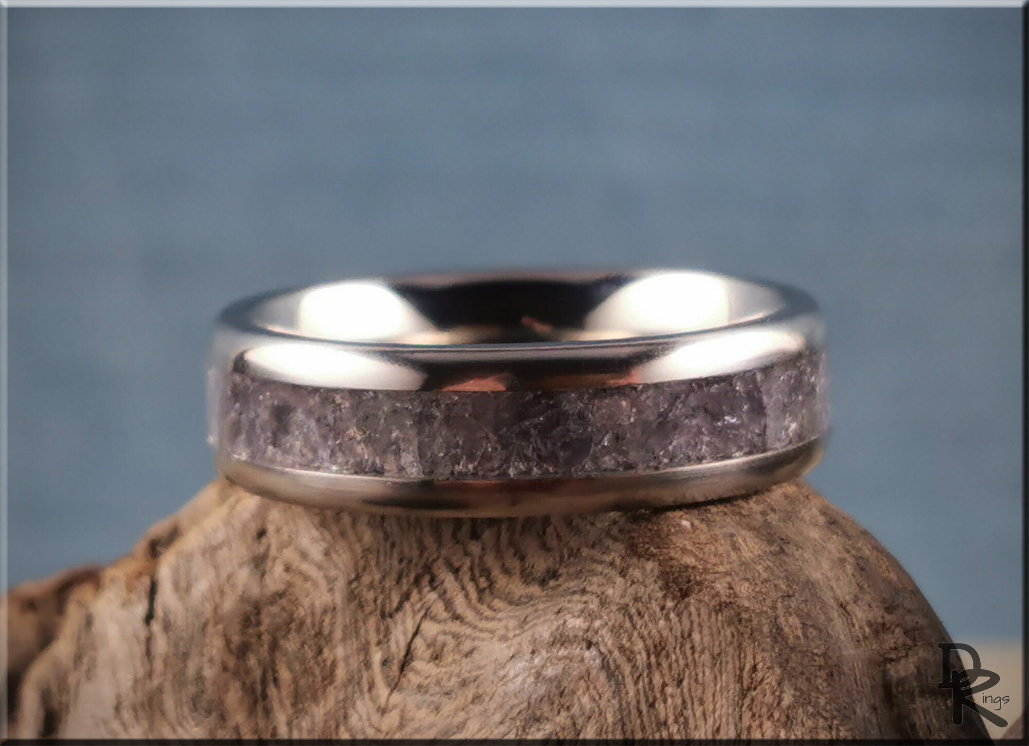 DR Rings titanium ring with inlay featuring a textured stone design on a wooden surface