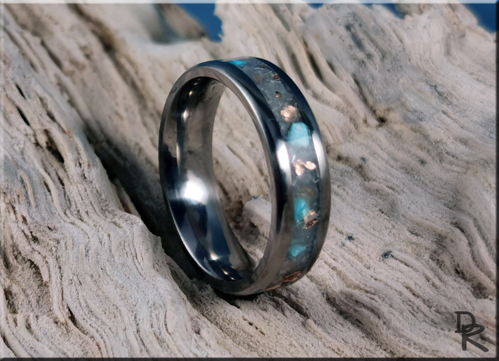 DR Rings titanium ring with inlay featuring blue and copper accents on textured wood background