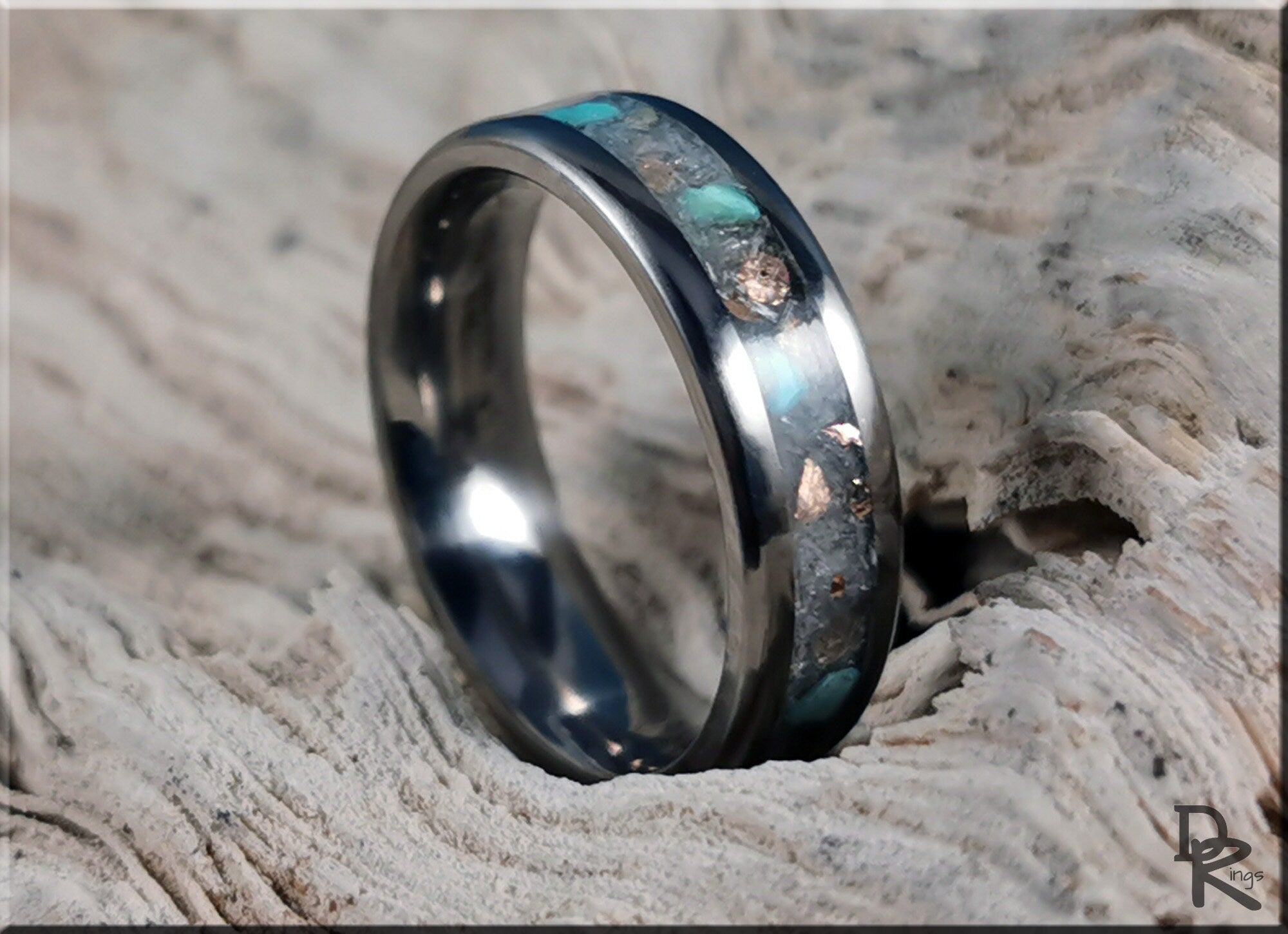 DR Rings titanium ring with inlay featuring turquoise and metallic stone design on textured wood
