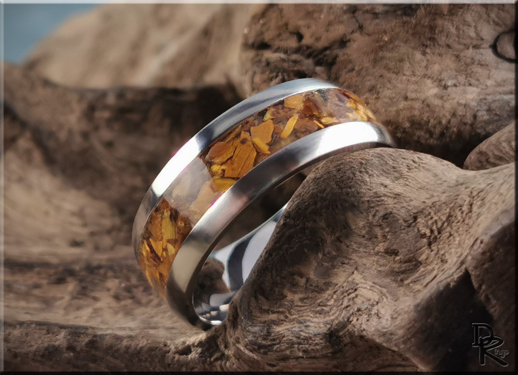 DR Rings titanium ring with inlay featuring amber-colored stone set in polished metal band
