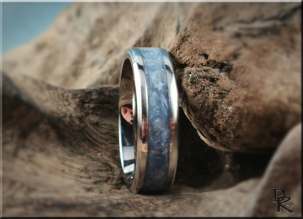 DR Rings titanium ring with kyanite blue stone inlay set on a natural wood background