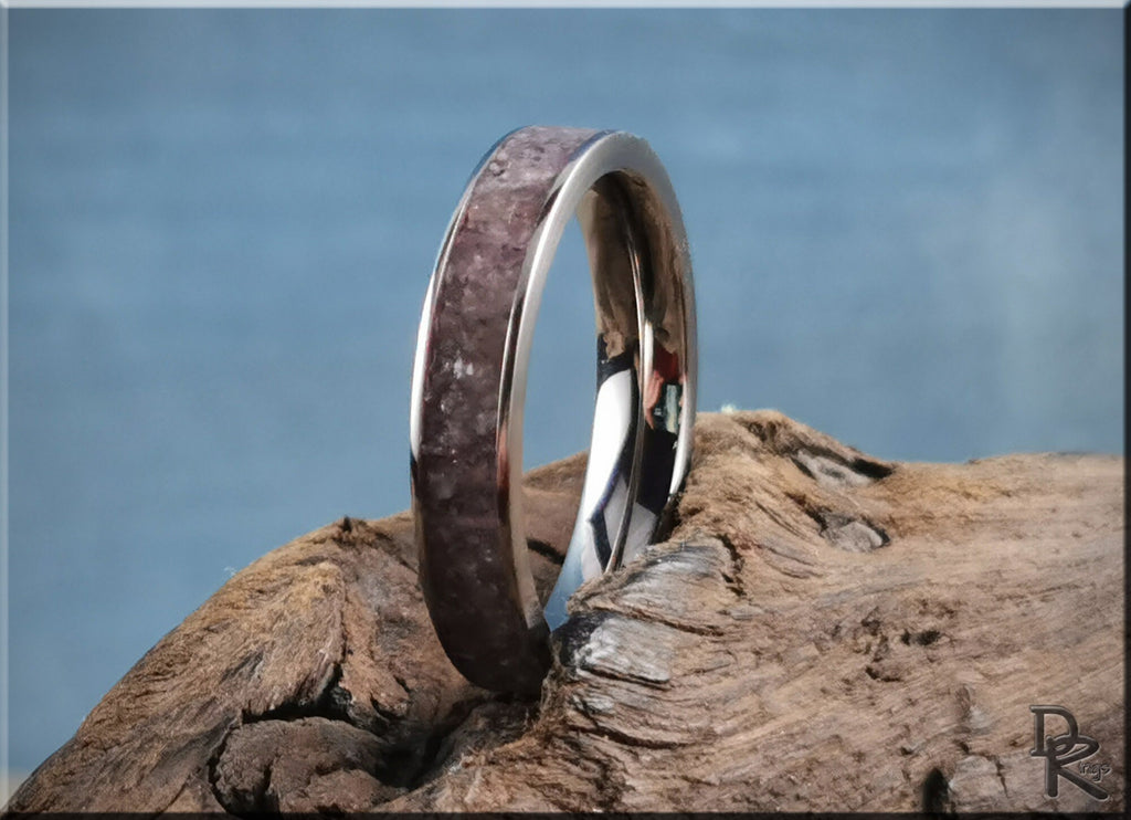 Titanium ring with lepidolite inlay displayed on rustic wood background by DR Rings