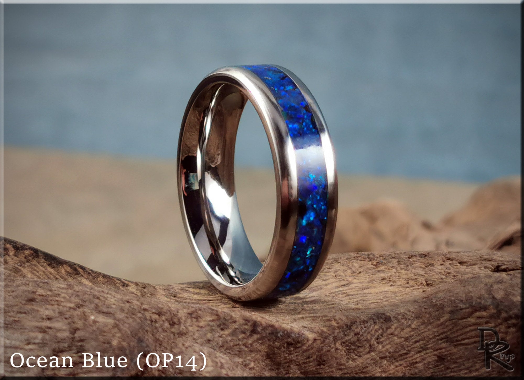 DR Rings titanium ring with opal inlay in ocean blue color displayed on wood surface