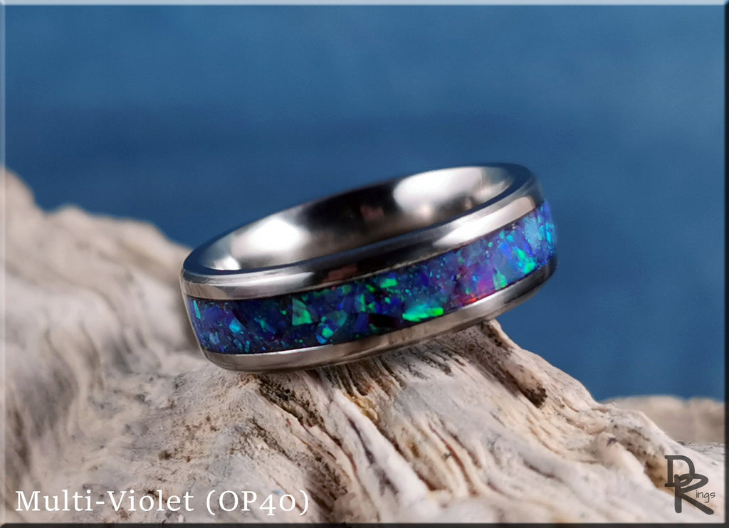Titanium ring with opal inlay featuring multi-violet colors resting on textured wood