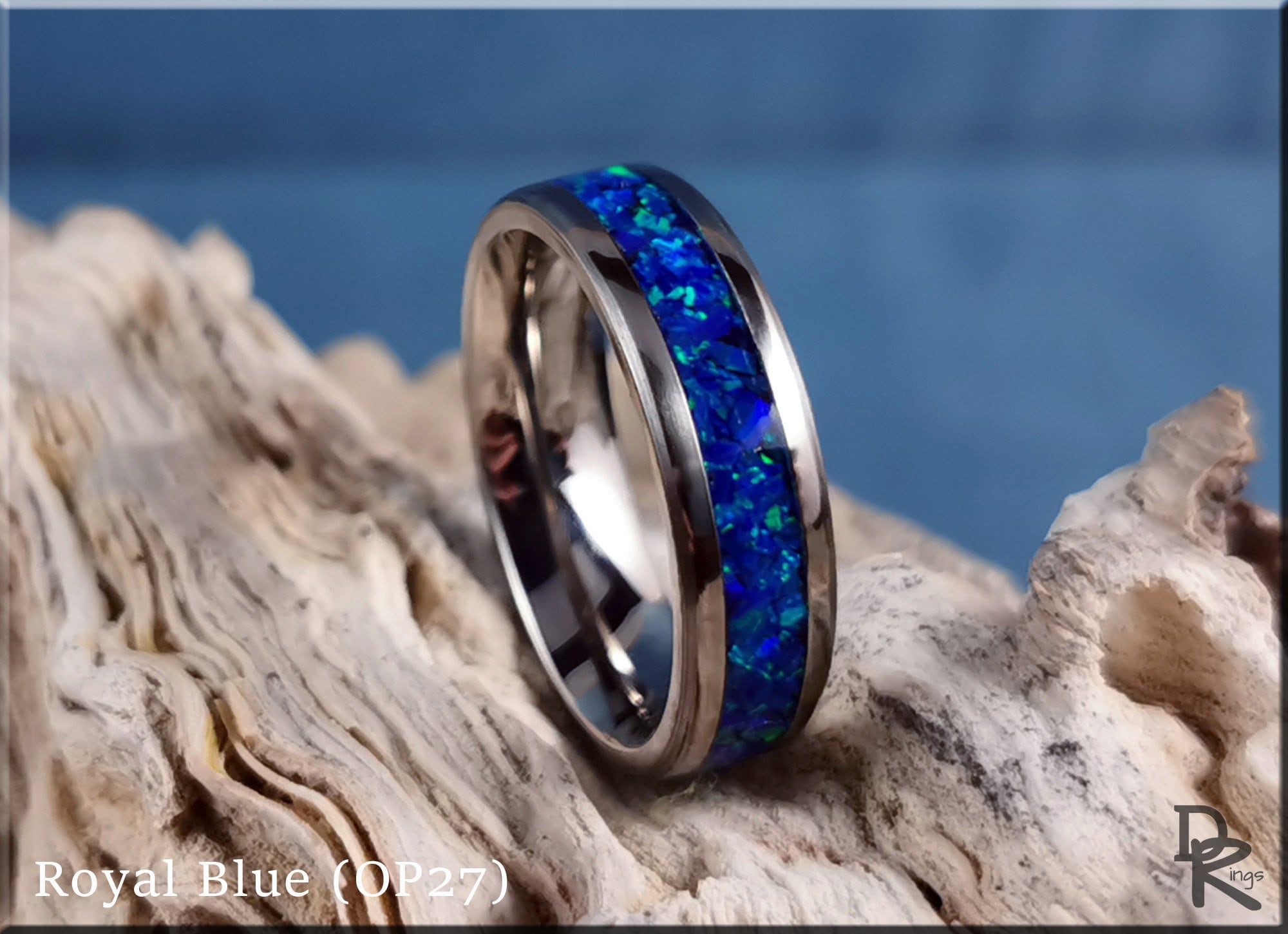DR Rings titanium ring with opal inlay featuring royal blue vibrant colors on natural wood background
