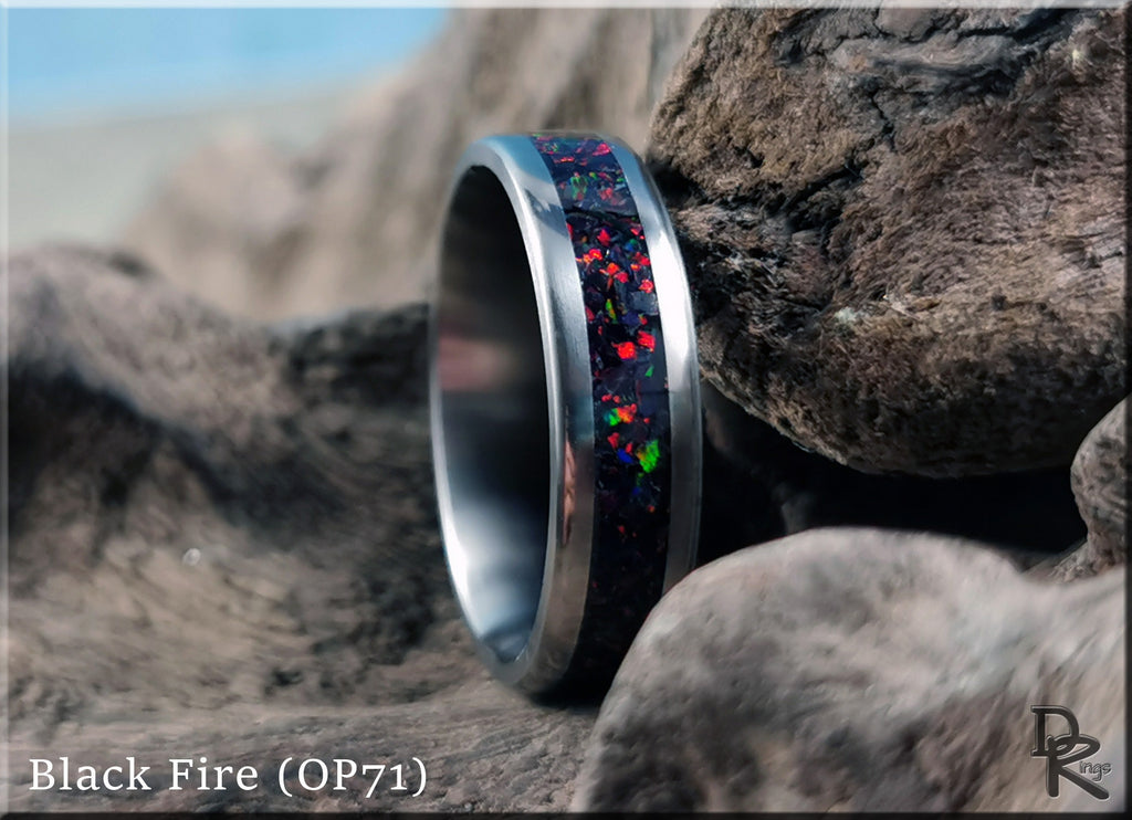 DR Rings titanium ring with opal inlay featuring a black fire design set against natural rocks