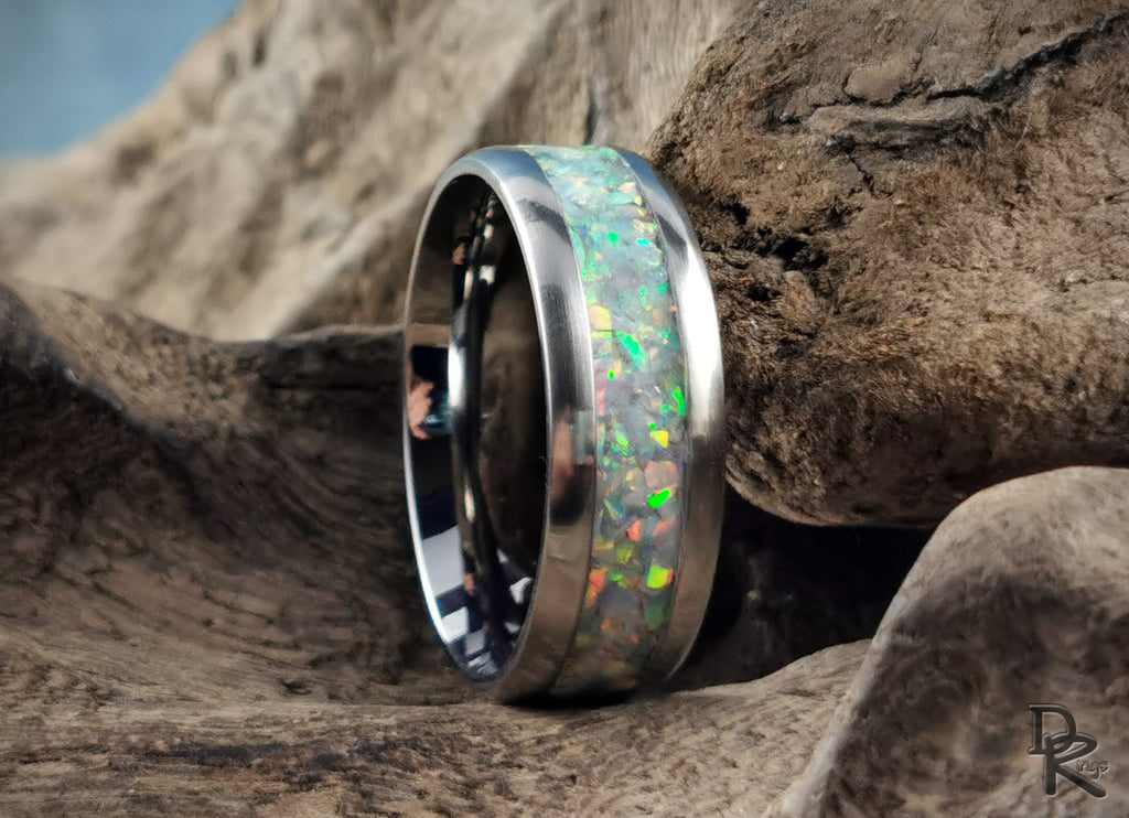 DR Rings titanium ring with opal inlay showcasing vibrant colors and polished silver edges on a natural wood background