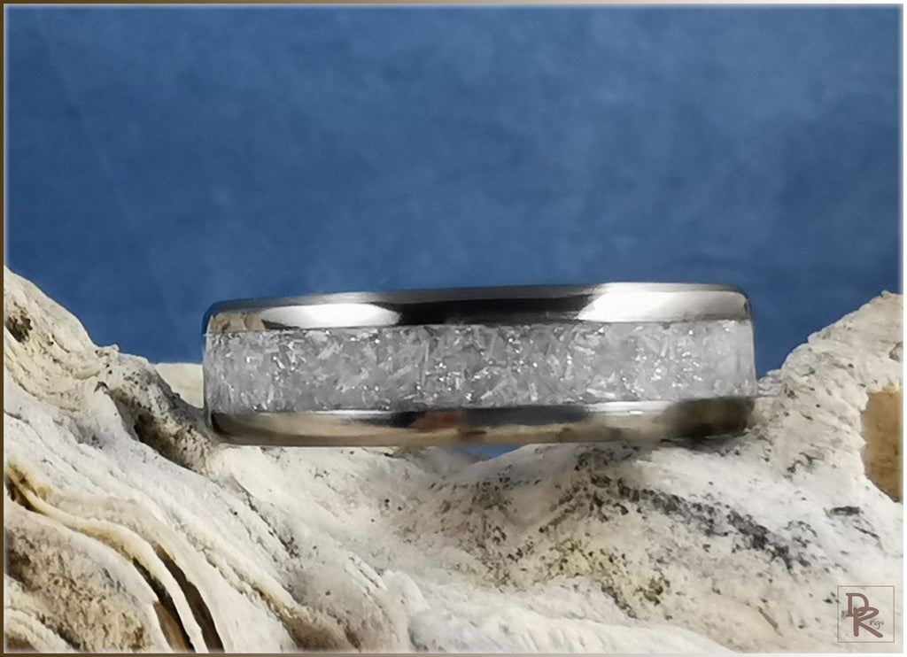 Titanium ring with selenite inlay showing crystal texture on natural stone background