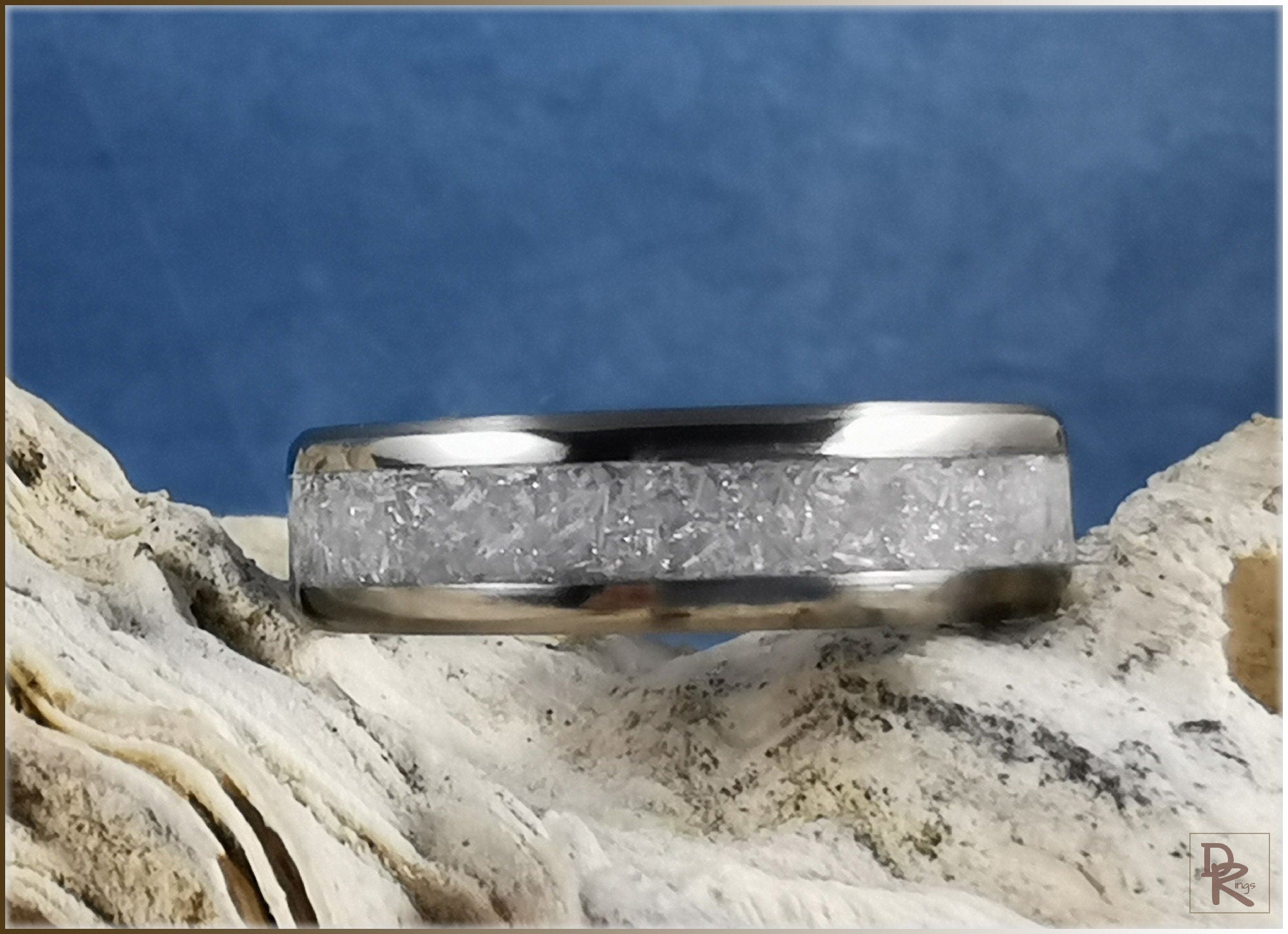 Titanium ring with selenite inlay showing crystal texture on natural stone background
