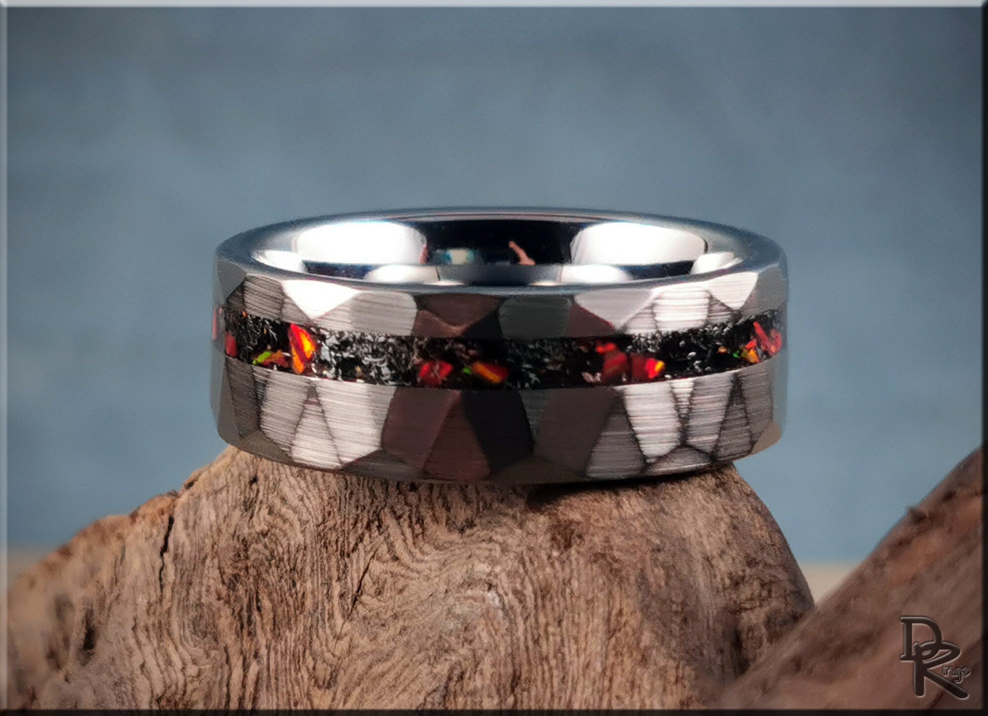 DR Rings tungsten as a ring with dark faceted surface and fiery inlay detail on wood background