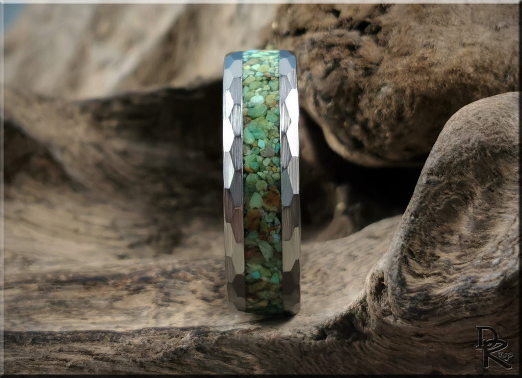 DR Rings tungsten as a ring featuring faceted edges and a green stone inlay on a natural wood background