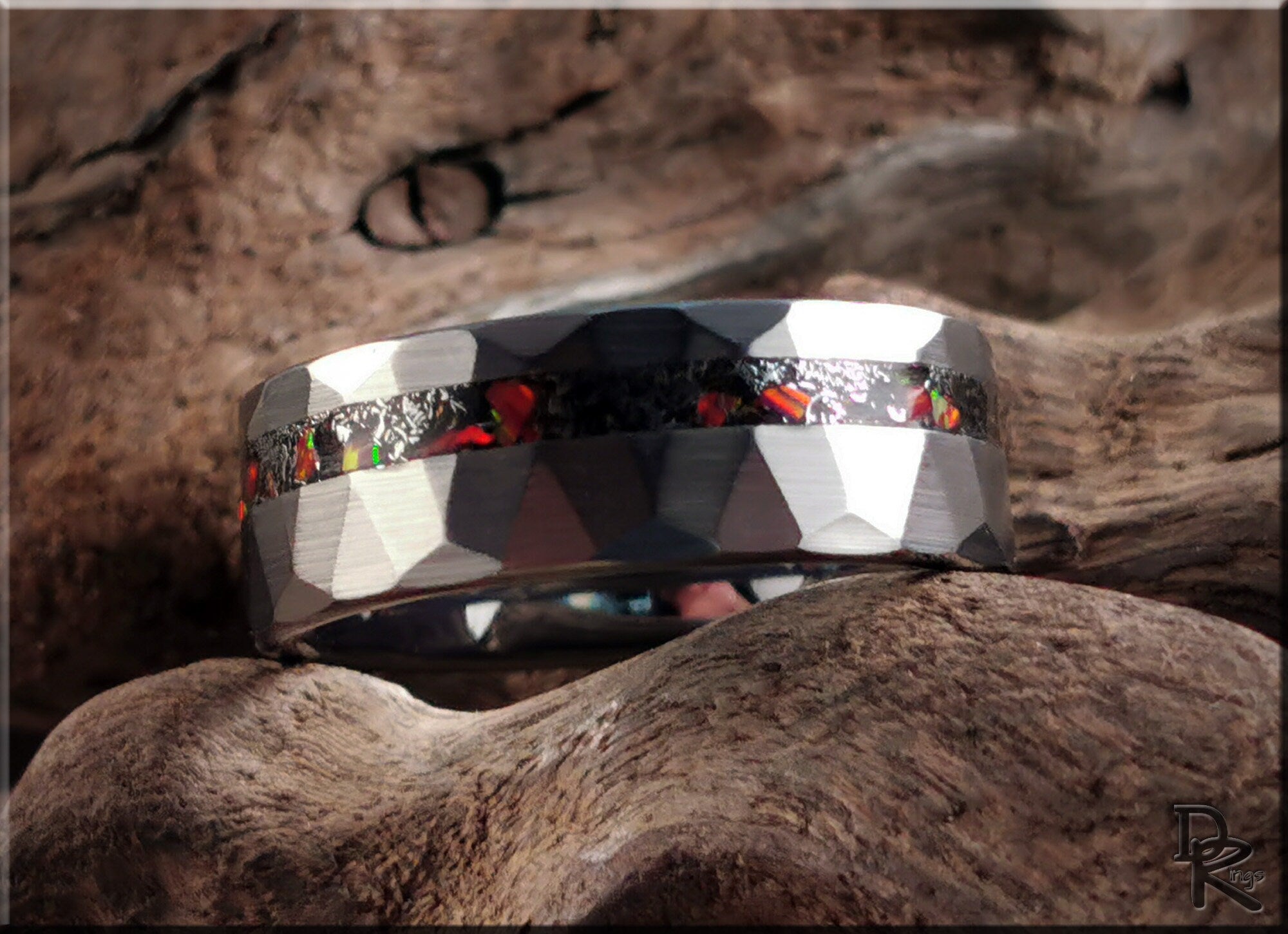 DR Rings tungsten as a ring with faceted silver finish and colorful inlay detail on rustic wood background