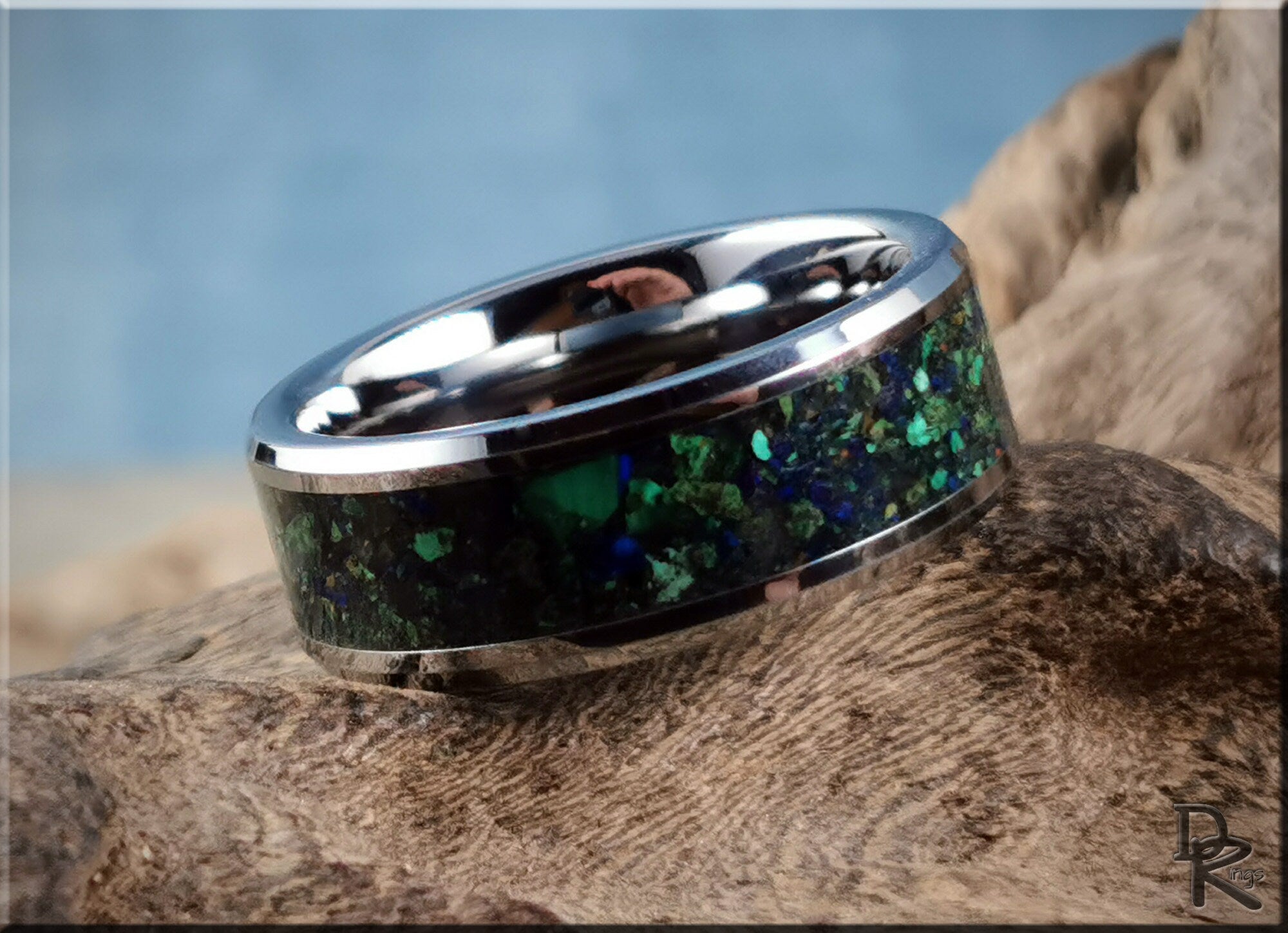 DR Rings tungsten ring carbide with green and blue stone inlay on a textured wooden surface