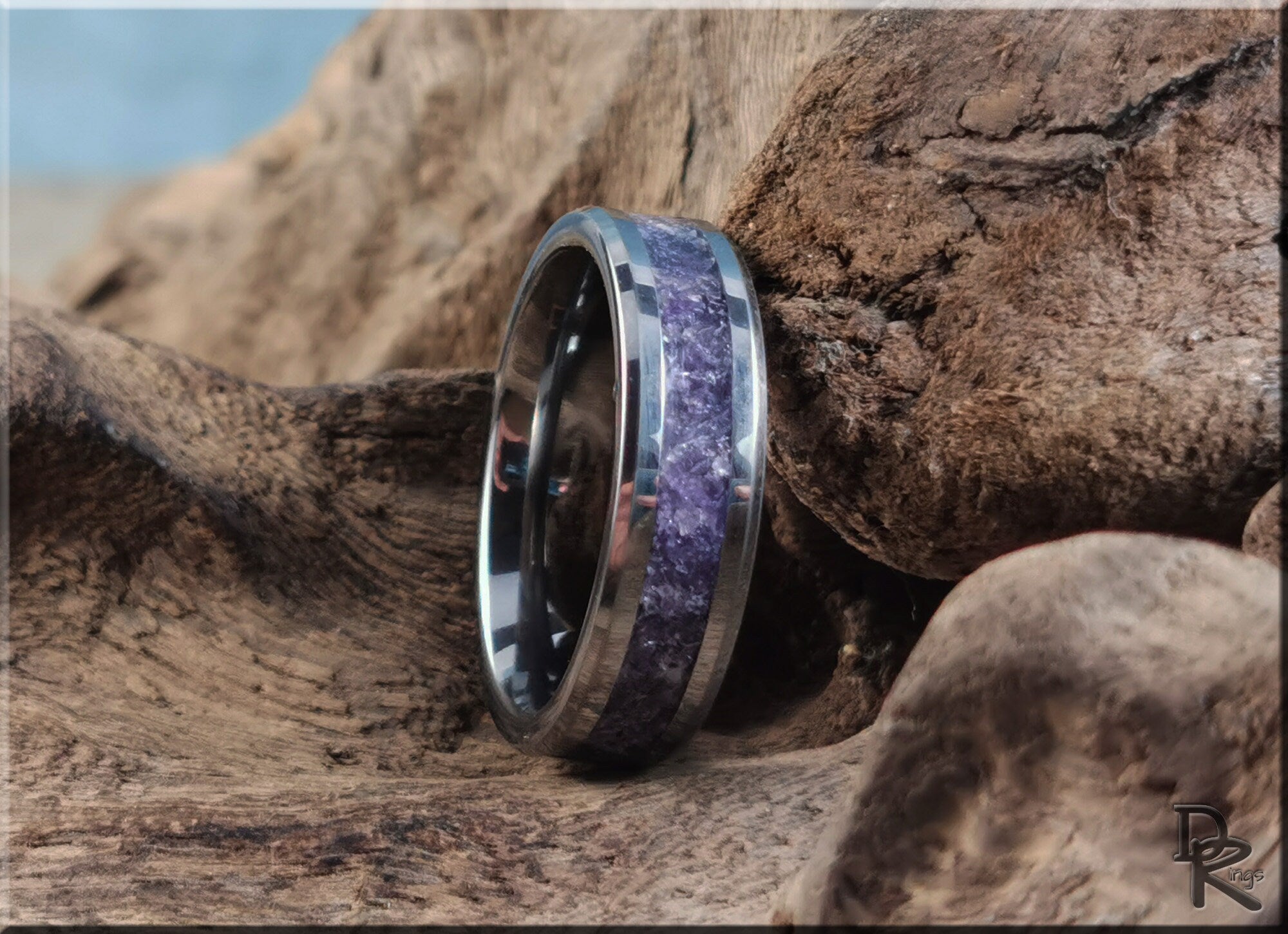 DR Rings tungsten ring with amethyst purple stone inlay on rustic wooden background