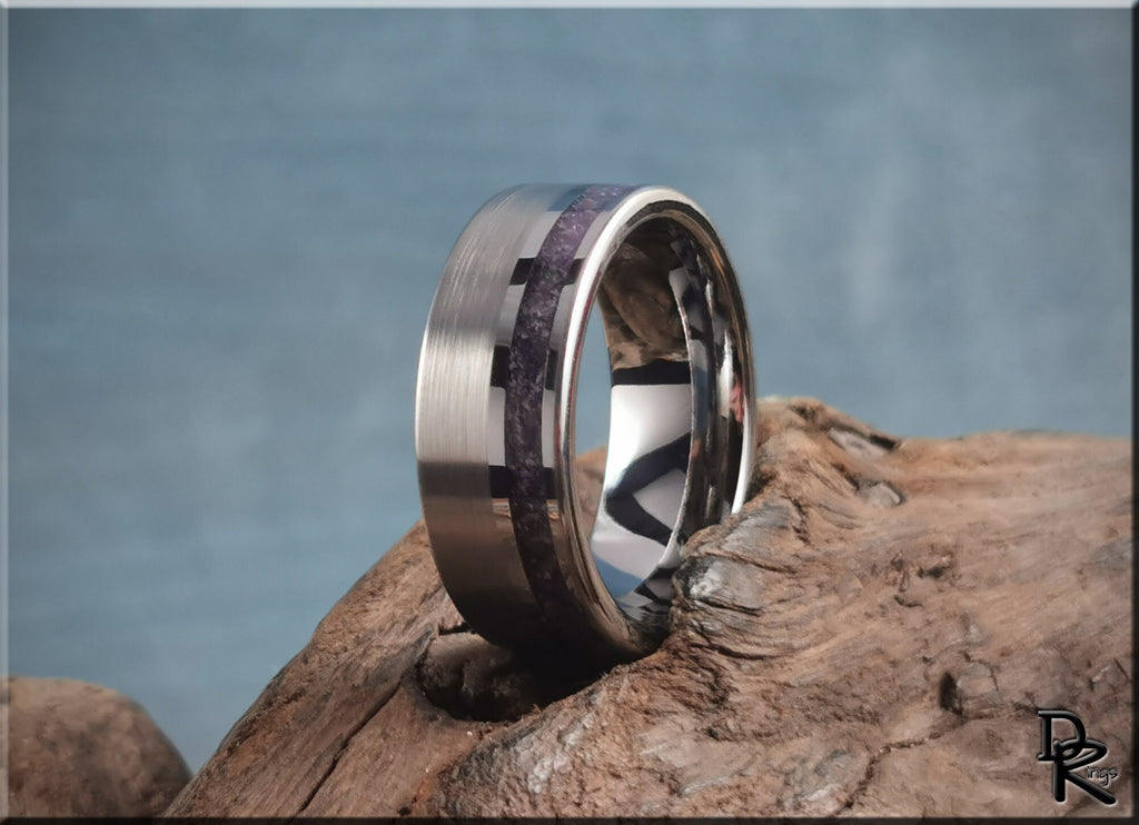 Tungsten ring with amethyst inlay featuring brushed and polished finishes on wood background