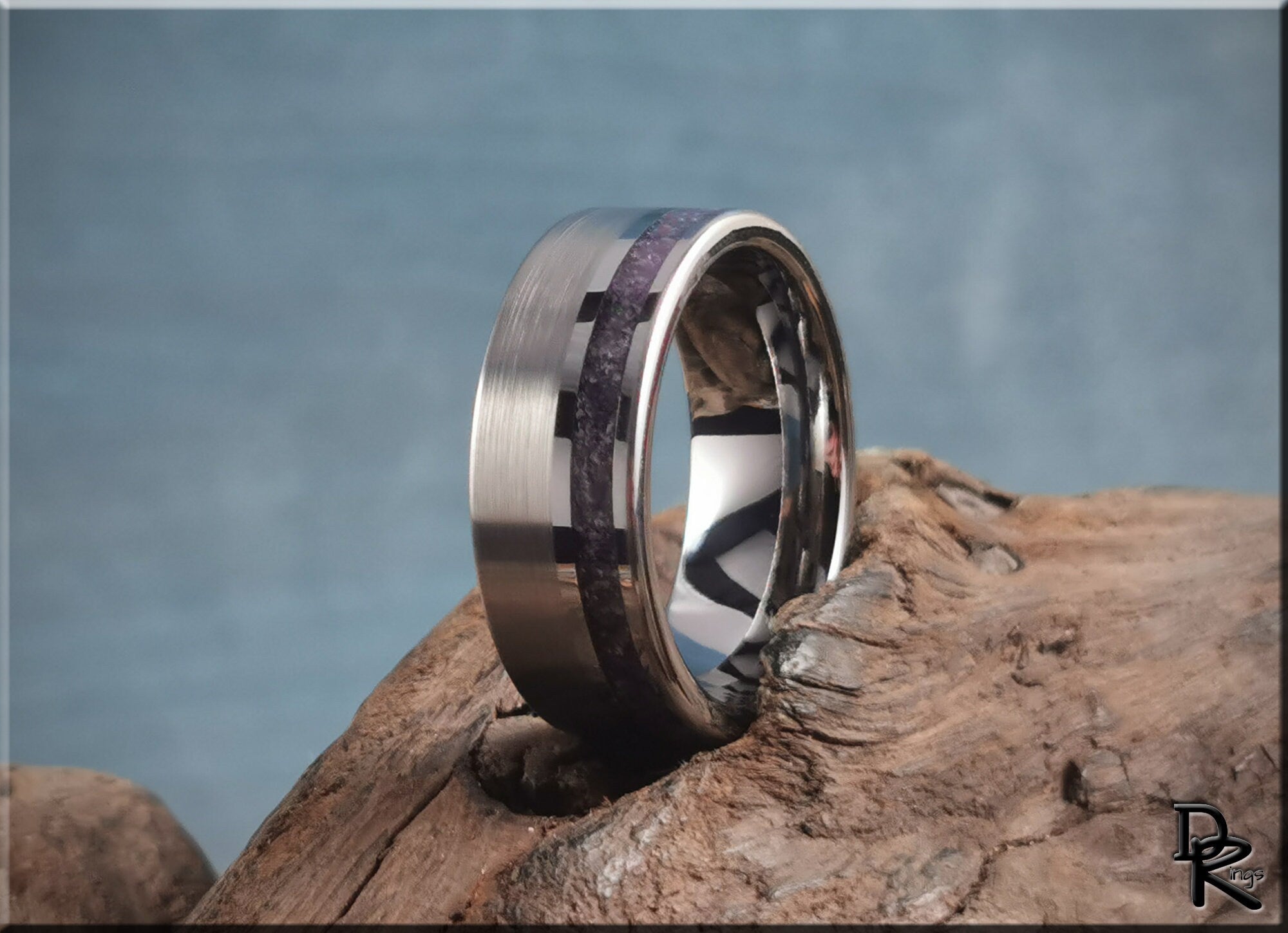 Tungsten ring with amethyst inlay featuring brushed and polished finishes on wood background